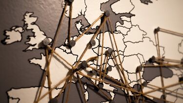 A map of the world with pins and string