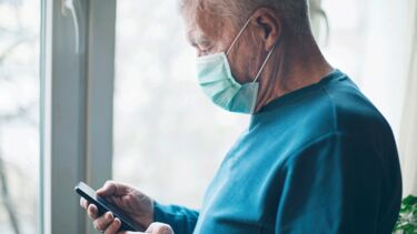Man wearing a medical mask and texting
