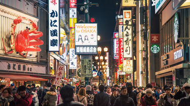 People walking down a busy street in Osaka, Japan.