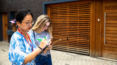 Students write notes at new housing development during fieldwork