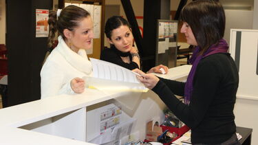 University staff helping students at a front desk
