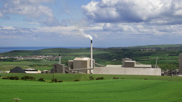 A view of the former mine that's now Boulby Underground Laboratory from the outside. Rolling hills and the sea are visible in the background.