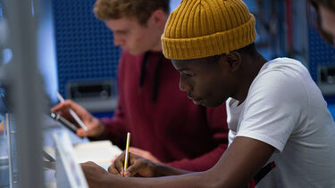 Mechanical engineering students working with calculators