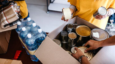 Small mixed race group of people working in charitable foundation food bank