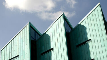 The top of the information commons against a sky backdrop.