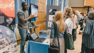 Man presents his research at stand