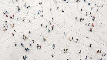 Bird's eye image of people stood apart from one another with a series of lines on the ground connecting them together