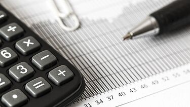 Calculator, paper, paperclip and pen