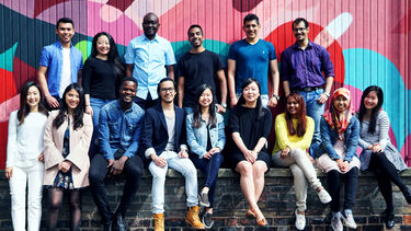 A collection of University of Sheffield students from different backgrounds, ethnicities and cultures posing for a photograph on campus.  