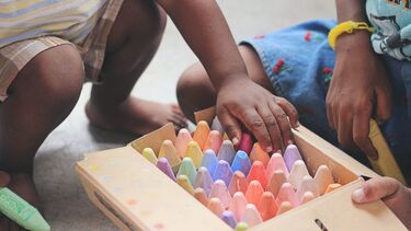 Two children playing with crayons