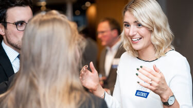 An alumna talking with a student