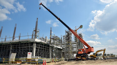 A crane in front of a building in construction