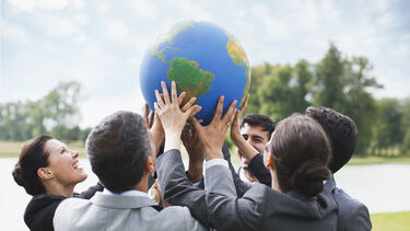 People holding a globe together