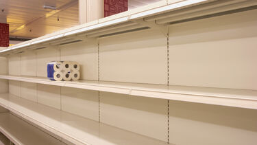 Panic buying causing shortages of products shown by one roll of toilet paper left on a supermarket shelf.