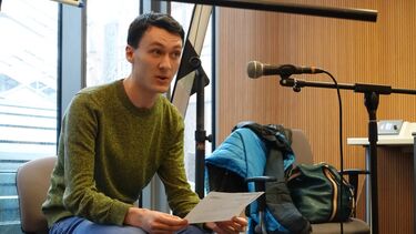 Male student reads text in mocrophone