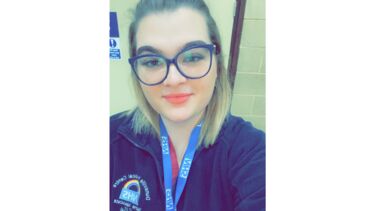 Female Apprentice smiling at camera with glasses