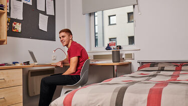 male student sat at table studying 