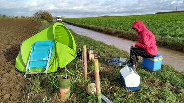 Scientist collecting ground water samples in a field