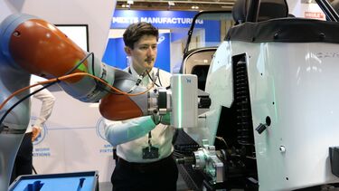 A person working with multiple robots on an assembly line
