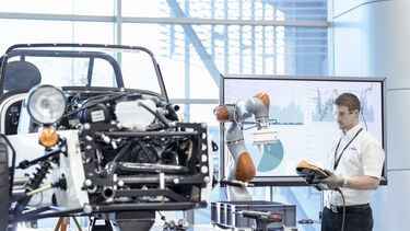 A man working with a robot at the Reconfigurable Assembly Integrated Demonstrator, or Project RAID, at Factory 2050