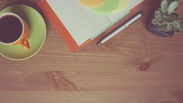 Coffee notebook plant and pen on desk