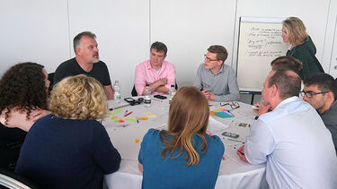 A group sitting around a table as part of a workshop