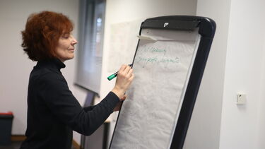 A woman writing on a flipchart