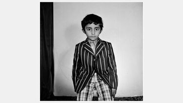 A vintage studio portrait of a young Asian boy