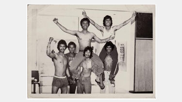A vintage photo of a group of friends, some riding on the others' shoulders