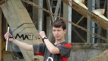 Boy holding a sign that says 'amazing'.