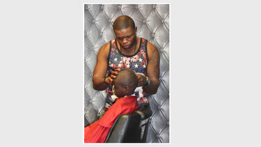 A man shaving a boy's head