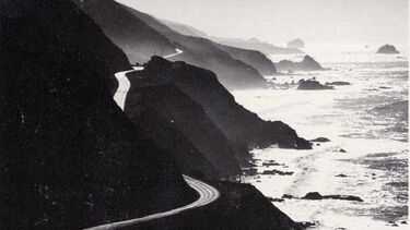Artwork of a road winding around hills next to the sea