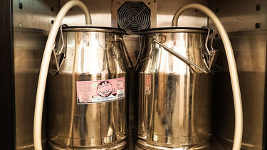 Two milk churns connected to pumps