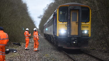 Engineers stood next to a stationary passenger train