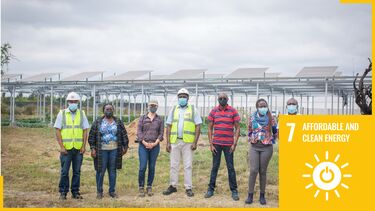 Group of people wearing safety clothing and masks in field