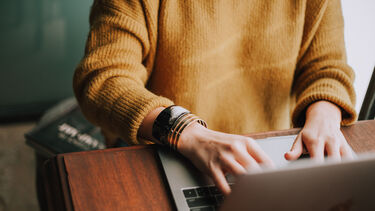 Close up of person's hands using a laptop