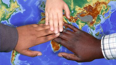 Three hands over a map of the world