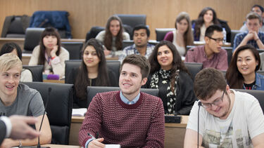 A photograph of a diverse group of MBA students in a lecture theatre.
