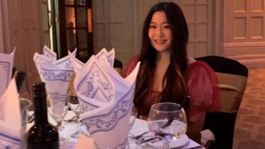 Cheryl attending a dinner party and sat at the pre-set dinner table