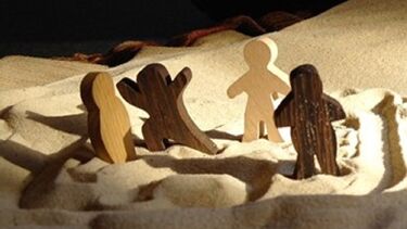 An image of figures in sand