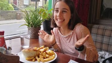 Ines, in a restaurant with a pie and a monopoly game on the table