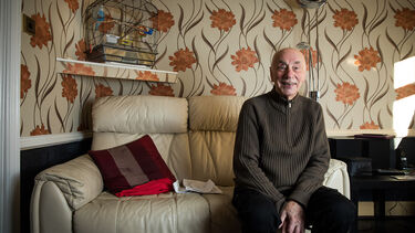 Ken Bury in his home on a sofa