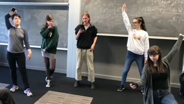 Group of 4 students striking a pose