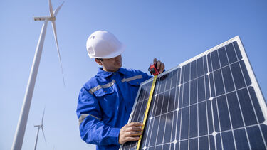 A man measuring a solar panel.