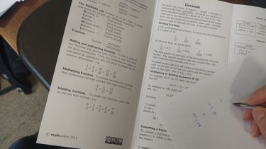 Image of some GCSE maths and a calculation of a fraction