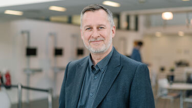 Damian Hodgson wearing a grey shirt and dark grey jacket.