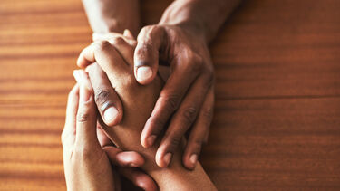 close up of two people holding hands on a table