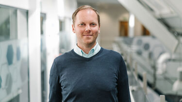 Stephen Allen, stood on the mezzanine walkway, wearing a dark blue jumper and light blue shirt.