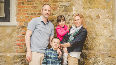 Portrait of the Edwards family - Mum and Dad with two children. The little girl Robbie wears leg braces.