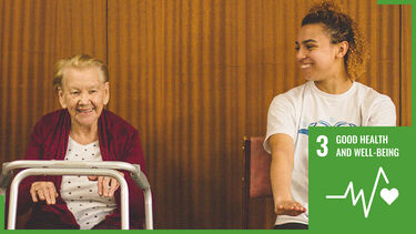 old lady sat next to student doing exercises with SDG3 logo overlaid